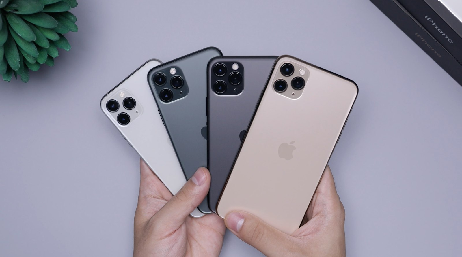 Cuatro iPhone en abanico en una mano